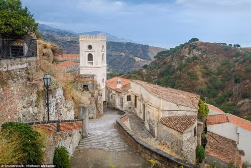 Trong phim "Bố già" của nhà văn Mario Puzo, thị trấn Modica ở vùng Sicily là quê hương của nhân vật ông trùm mafia Vito Corleone. Ảnh: Pinimg. Du khách đến thị trấn thường ăn bánh quy ngọt và uống Granitas tại quán bar Vitelli, nơi nhân vật Michael Corleone từng ngồi, khi về quê cha để lẩn trốn sự truy đuổi. Ảnh: James Dunn/Daily Mail. Quán bar trong phim và ngoài đời thực không có sự khác biệt, bên ngoài được phủ xanh bằng giàn cây leo. Ảnh: Shutterstock/Goran Vrhovac. Một cảnh trong phim "Bố già". Trong phim, Michael Corleone cùng các bạn của mình đến quán bar để xin cưới con gái chủ quán, người anh đã yêu ngay lần đầu gặp trên một con đường làng. Ảnh: Paramount Pictures/REX/Shutterstock. Từ bar Vitelli, du khách có thể nhìn thấy nhà thờ Savoca, nơi đạo diễn Francis Ford Coppola quay cảnh đám cưới của Michael Corleone và người vợ đầu tiên. Ảnh: Shutterstock/Anadman BVBA. Nhờ những cảnh quay trong bộ phim huyền thoại, Sicily trở thành thỏi nam châm thu hút du khách từ khắp nơi trên thế giới đổ về. Ảnh: James Dunn/Daily Mail. Nhiều du khách thích thú khi được thuê lái những chiếc xe hơi cổ đến núi Etna, ngọn núi lửa nổi tiếng của hòn đảo và ghé thăm những vườn nho trong vùng. Ảnh: James Dunn/Daily Mail. Người dân Sicily ưu ái dành tình cảm cho đạo diễn Francis Ford Coppola bằng một bức tượng kim loại hình ông bên máy quay phim. Phía xa là nhà thờ Santa Maria Degli Angeli, nơi quay cảnh ông trùm Michael Corleone kết hôn với người vợ đầu tiên. Ảnh: James Dunn/Daily Mail. Cảnh quan vùng Sicily giữ được nét trầm mặc, yên tĩnh và có phần bí hiểm, giống như những gì đã xuất hiện trên phim cách đây hơn 40 năm. Ảnh: Shutterstock/Nikiforov Alexander. Một địa điểm nổi tiếng khác ở Sicily là nơi nhân vật Vito Corleone sinh ra, xuất hiện trong "Bố già" phần III. Ảnh: James Dunn/Daily Mail. Ngoài khu nội thất sang trọng, bên ngoài biệt thự là khu vực ăn uống mở. Du khách có thể thưởng thức rượu vang và món ăn ngon của địa phương vào những buổi chiều nắng nóng. Ảnh: James Dunn/Daily Mail. Không gian mở hướng ra biển mang lại cảm giác thư giãn yên tĩnh. Ảnh: James Dunn/Daily Mail. Sau chuyến thăm các địa danh xuất hiện trong phim, du khách có thể ghé một nhà hát cổ tuyệt đẹp nằm trên quả đồi nhỏ nhìn ra vịnh. Ảnh: Shutterstock/Arts lllustrated Studios.