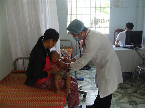 Bác sỹ Trạm quân dân y kết hợp Đồn biên phòng Cửa khẩu quốc tế Dinh Bà (Đồng Tháp) khám bệnh cho người dân Campuchia. Ảnh: Mai Hưng- TTXVN