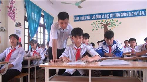 Thầy Hùng hướng dẫn các em học sinh môn vẽ. Ảnh: Hoa Mai - TTXVN