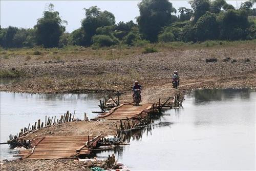 Người dân tạm thời lưu thông qua chiếc cầu tạm cách đó khoảng 200m. Ảnh: Thanh Hải - TTXVN