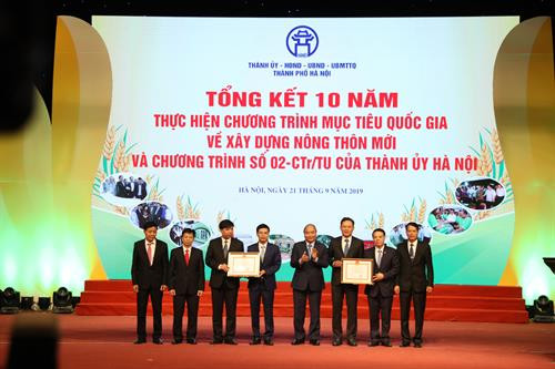 Nhân dịp này, Thủ tướng Chính phủ Nguyễn Xuân Phúc đã trao Bằng công nhận huyện đạt chuẩn nông thôn mới năm 2018 cho huyện Gia Lâm và huyện Quốc Oai. Lãnh đạo thành phố cũng trao Cờ thi đua xuất sắc của thành phố Hà Nội cho các tập thể có thành tích xuất sắc. Trong ảnh: Bí thư Thành ủy Hà Nội Hoàng Trung Hải trao Cờ thi đua xuất sắc của thành phố Hà Nội cho các tập thể. Chủ tịch Ủy ban Nhân dân thành phố Hà Nội Nguyễn Đức Chung trao Cờ thi đua xuất sắc của thành phố Hà Nội cho các tập thể. Phó Bí thư Thường trực Thành ủy Hà Nội Ngô Thị Thanh Hằng trao Bằng khen của Ban Thường vụ Thành ủy Hà Nội cho các tập thể và cá nhân. Chủ tịch Hội đồng Nhân dân thành phố Hà Nội Nguyễn Thị Bích Ngọc trao Bằng khen của Ban Thường vụ Thành ủy Hà Nội cho các tập thể và cá nhân.