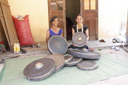 Bà Y Kích (áo xanh), làng Kon Go 1, phấn khởi bên bộ cồng chiêng quý của gia đình. Bà Y Kích (áo xanh), làng Kon Go 1, phấn khởi bên bộ cồng chiêng quý của gia đình.
