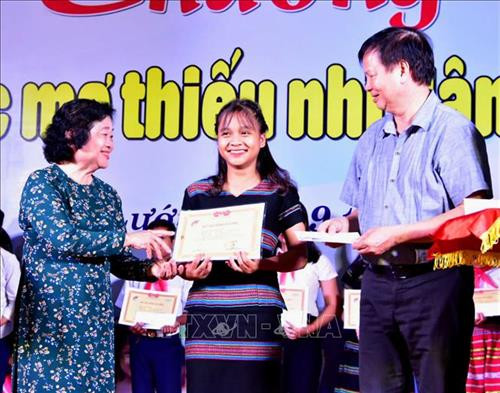 Ban tổ chức trao học bổng cho trẻ em có hoàn cảnh khó khăn. Ảnh: Tường Vi - TTXVN