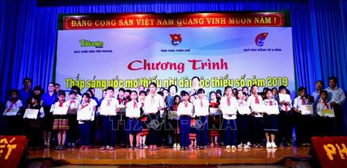 Ban tổ chức trao học bổng cho trẻ em có hoàn cảnh khó khăn. Ảnh: Tường Vi - TTXVN