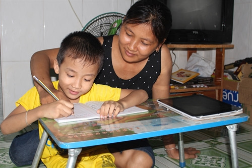 Chị Nguyễn Thị Hạnh dạy con học chữ