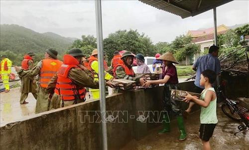 Các cán bộ chiến sĩ công an tỉnh Quảng Bình hỗ trợ, tiếp tế lương thực, mì tôm, nước uống cho nhân dân vùng lũ. Ảnh: TTXVN