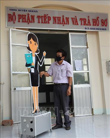 Anh Trương Văn Thành với sáng kiến máy tự động nhắc nhở mọi người phòng dịch COVID-19. Ảnh: Cao Nguyên – TTXVN