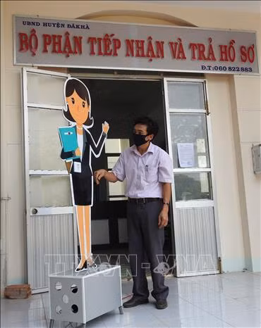 Anh Trương Văn Thành với sáng kiến máy tự động nhắc nhở mọi người phòng dịch COVID-19. Ảnh: Cao Nguyên – TTXVN