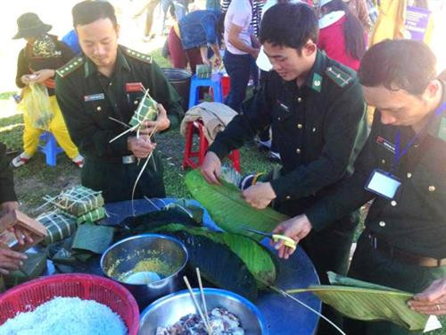 Bộ đội biên phòng cửa khẩu Nam Giang gói bánh chưng cùng bà con. Ảnh bienphong.com.vn