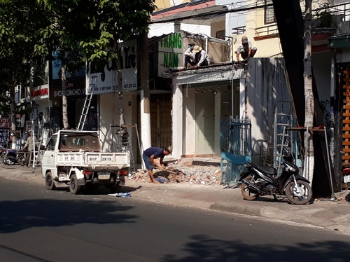 Người dân tự tháo dỡ những công trình vi phạm lấn chiếm vỉa hè. Ảnh: Huyền Trang - TTXVN Người dân tự tháo dỡ những công trình vi phạm lấn chiếm vỉa hè. Ảnh: Huyền Trang - TTXVN