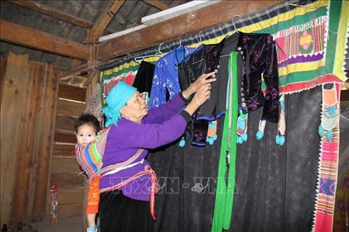 Bà Lò Thị Dần chọn những bộ quần áo mới để mặc vào ngày đầu năm. Ảnh: Việt Dũng - TTXVN Bà Lò Thị Dần chọn những bộ quần áo mới để mặc vào ngày đầu năm. Ảnh: Việt Dũng - TTXVN