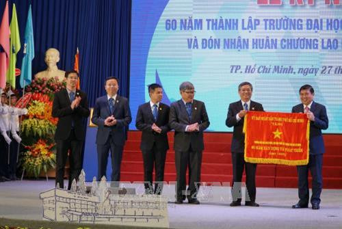 Chủ tịch Ủy ban Nhân dân Thành phố Hồ Chí Minh Nguyễn Thành Phong trao cờ thi đua cho trường Đại học Bách Khoa Thành phố Hồ Chí Minh. Ảnh: Phương Vy-TTXVN