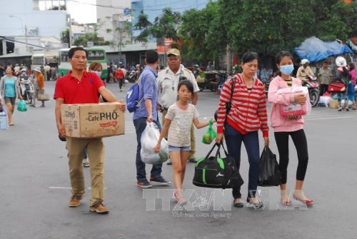 Người dân lỉnh khỉnh đồ đạc xuống bến xe Miền Tây sau lễ. Ảnh: Mạnh Linh-TTXVN