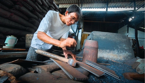Người thợ bậc tuổi trung niên đang tiếp bước nghề rèn thế hệ trước.