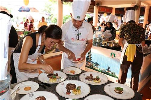 Ông Vicent Floreani, Tổng lãnh sự Pháp tại Thành phố Hồ Chí Minh (ngoài cùng bên phải) đang trang trí món ăn chính. Ảnh: Xuân Khu-TTXVN