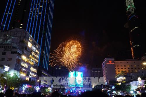 Người dân xem bắn pháo hoa trong thời khắc chuyển giao giữa năm cũ và năm mới 2018 tại đường Nguyễn Huệ, Thành phố Hồ Chí Minh. Ảnh: Phương Vy -TTXVN. Người dân xem bắn pháo hoa trong thời khắc chuyển giao giữa năm cũ và năm mới 2018 tại đường Nguyễn Huệ, Thành phố Hồ Chí Minh. Ảnh: Phương Vy -TTXVN.