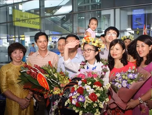 Nguyễn Khánh Linh trong vòng tay chào đón của người thân, thầy cô và bạn bè. Ảnh: Thanh Tùng-TTXVN