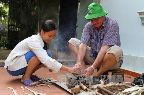 Khách du lịch nước ngoài trải nghiệm các công đoạn làm nón lá.