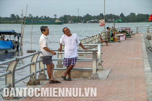 Ông Trần Văn Phong (74 tuổi, bên trái) trò chuyện cùng người bạn hàng xóm trên bờ kè trong một buổi chiều cuối tháng 2/2020. Ông Phong chia sẻ, dù đối mặt hai lần sạt lở nhưng ông cũng như người dân ở vàm Thới An đều muốn tiếp tục được sống ở mảnh đất mà họ đã gắn bó hàng chục hàng năm. Ông bày tỏ sự cảm kích với lãnh đạo thành phố Cần Thơ, chính quyền địa phương đã kịp thời khắc phục hậu quả sạt lở, giúp người dân ổn định cuộc sống.