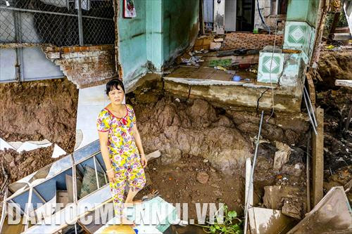 Bà Nguyễn Thị Bích Liên thẩn thờ đứng trước ngôi nhà bị đổ sập của gia đình do sạt lở