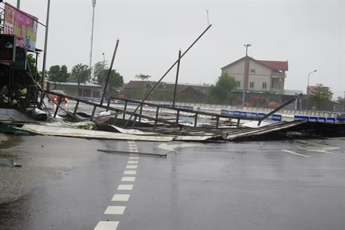 Biển quảng cáo và mái tôn của người dân bị bão giật gãy, đổ xuống đường. Ảnh: Phan Quân - Công Tường/TTXVN Biển quảng cáo và mái tôn của người dân bị bão giật gãy, đổ xuống đường. Ảnh: Phan Quân - Công Tường/TTXVN