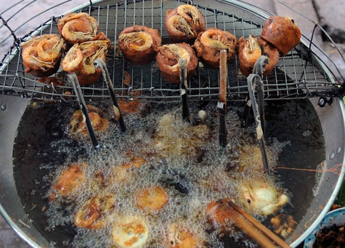 bánh Cống được chiên trong chảo ngập mỡ