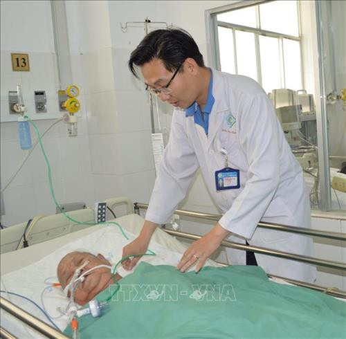 Bác sĩ thăm khám Bà mẹ Việt Nam Anh hùng Đinh Thị Thà sau phẫu thuật. Ảnh: TTXVN phát Bác sĩ thăm khám Bà mẹ Việt Nam Anh hùng Đinh Thị Thà sau phẫu thuật. Ảnh: TTXVN phát