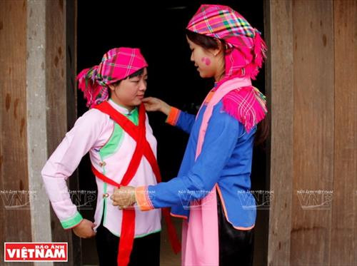 Cô dâu được chị gái chuẩn bị trang phục trong ngày cưới. Chú rể dùng ngựa giấy đi đón cô dâu. Nhà trai cử một người phụ nữ to khỏe cõng cô dâu về nhà trai. Cô dâu chú rể được thầy cúng dùng nước té lên người để đuổi tà ma trước khi lên đường sang nhà trai. Cô dâu được nhà trai đón về nhà làm lễ. Chú rể mở tấm khăn đỏ khi đón cô dâu về phòng cưới. Cô dâu về nhà chồng, cởi băng đỏ cho chú rể. Cô dâu được chị gái chuẩn bị trang phục trong ngày cưới. Chú rể dùng ngựa giấy đi đón cô dâu. Nhà trai cử một người phụ nữ to khỏe cõng cô dâu về nhà trai. Cô dâu chú rể được thầy cúng dùng nước té lên người để đuổi tà ma trước khi lên đường sang nhà trai. Cô dâu được nhà trai đón về nhà làm lễ. Chú rể mở tấm khăn đỏ khi đón cô dâu về phòng cưới. Cô dâu về nhà chồng, cởi băng đỏ cho chú rể.