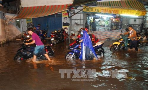 Đường An Dương Vương (quận 6) ngập sâu trong biển nước khiến hàng loạt phương tiện bị chết máy. Ảnh: Mạnh Linh - TTXVN