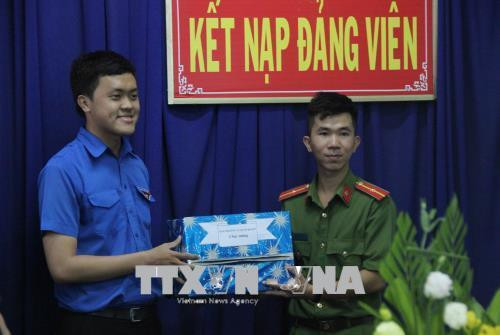 Đại diện Quận đoàn quận 9 tặng quà cho Thiếu úy Lê Nam Hải (phải) trong lễ kết nạp Đảng. Ảnh: Xuân Dự - TTXVN Đại diện Quận đoàn quận 9 tặng quà cho Thiếu úy Lê Nam Hải (phải) trong lễ kết nạp Đảng. Ảnh: Xuân Dự - TTXVN