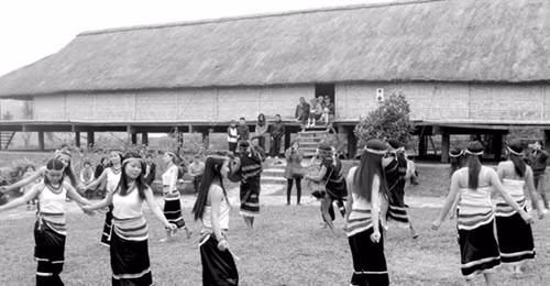 Các thiếu nữ múa ka đấu bên nhà dài của người Co. Ảnh: baoquangnam.vn