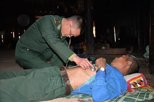 Cán bộ quân y Đồn Biên phòng Phiêng Pằn đến tận nhà khám bệnh cho người dân vùng biên. Ảnh: Hữu Quyết - TTXVN