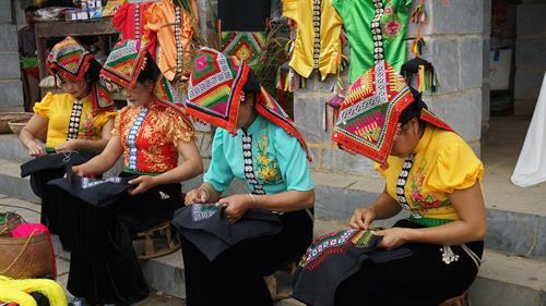 Những cô gái Thái trình diễn nghệ thuật thêu khăn Piêu tại phiên chợ. Ảnh: Hoàng Tâm