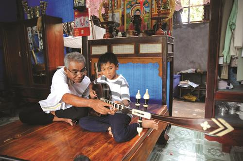Cứ mỗi khi rảnh rỗi, nghệ nhân Danh Xà Rậm lại hướng dẫn con cháu sử dụng nhạc cụ truyền thống của người Khmer.
