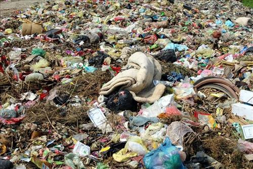 Bãi rác thôn Quan Bằng, xã Cẩm Vân, bốc mùi hôi thối do rác được xử lý bằng hình thức chôn lấp vì xã không có kinh phí đầu tư lò đốt rác. Ảnh: Nguyễn Nam-TTXVN