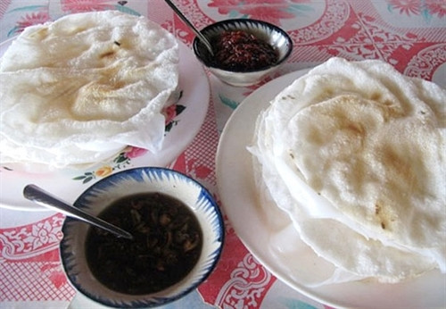 Một phần bánh tráng đập gồm hai cái bánh tráng nướng trên than nóng kẹp một cái bánh ướt ở giữa. Khi ăn, bạn phải dùng bàn tay xòe ra, đập nhẹ xuống cho bánh vỡ nát đều, sau xé ra từng mảng, cuốn lại như bánh cuốn rồi chấm mắm cái. Đây là loại nước chấm được pha từ đường, hành phi, dứa bằm nhỏ, tỏi và ớt sừng xanh. Bánh đập nổi tiếng nhất ở quán Bà Già, xã Cẩm Nam. Ảnh: Thiện Nguyễn Một phần bánh tráng đập gồm hai cái bánh tráng nướng trên than nóng kẹp một cái bánh ướt ở giữa. Khi ăn, bạn phải dùng bàn tay xòe ra, đập nhẹ xuống cho bánh vỡ nát đều, sau xé ra từng mảng, cuốn lại như bánh cuốn rồi chấm mắm cái. Đây là loại nước chấm được pha từ đường, hành phi, dứa bằm nhỏ, tỏi và ớt sừng xanh. Bánh đập nổi tiếng nhất ở quán Bà Già, xã Cẩm Nam. Ảnh: Thiện Nguyễn