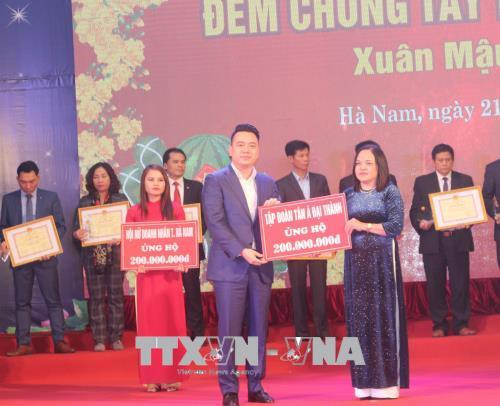 Trao tiền ủng hộ chương trình "Đêm chung tay Tết vì người nghèo - Xuân Mậu Tuất 2018". Ảnh: Nguyễn Thị Chinh-TTXVN Trao tiền ủng hộ chương trình "Đêm chung tay Tết vì người nghèo - Xuân Mậu Tuất 2018". Ảnh: Nguyễn Thị Chinh-TTXVN