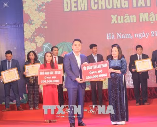 Trao tiền ủng hộ chương trình "Đêm chung tay Tết vì người nghèo - Xuân Mậu Tuất 2018". Ảnh: Nguyễn Thị Chinh-TTXVN Trao tiền ủng hộ chương trình "Đêm chung tay Tết vì người nghèo - Xuân Mậu Tuất 2018". Ảnh: Nguyễn Thị Chinh-TTXVN