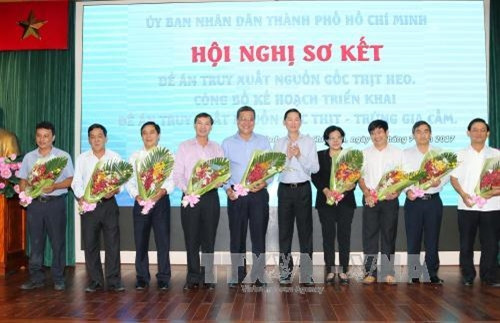 Phó Chủ tịch UBND Thành phố Hồ Chí Minh Trần Vĩnh Tuyến tặng hoa cho lãnh đạo các tỉnh, thành phố tích cực phối hợp thực hiện đề án truy xuất nguồn gốc thịt heo. Ảnh: Thanh Vũ-TTXVN