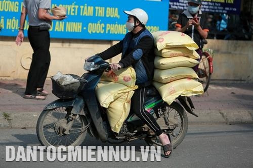 Người dân mang gạo đến đóng góp từ thiện với cây "ATM gạo" ở Nhà Văn hóa Nghĩa Tân, quận Cầu Giấy, Hà Nội.