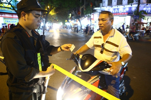 Người dân sống trong khu vực các phố đị bộ được tạo điều kiện dắt xe về nhà nếu có thẻ được cấp sẵn. Ảnh: TTXVN