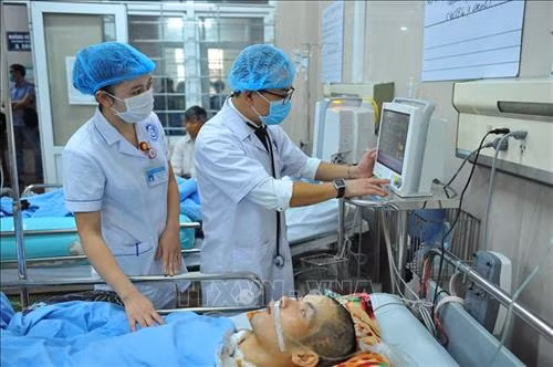 Bác sĩ Đinh Tự Vũ Ngọc thăm khám cho bệnh nhân. Ảnh: Minh Đức - TTXVN