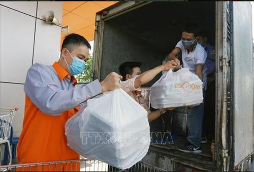 Các suất ăn được nhân viên Saigon Co.op vận chuyển ra xe chuyên chở đến khu vực cách ly tập trung trên địa bàn Thành phố Hồ Chí Minh. Ảnh: TTXVN phát