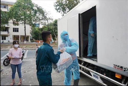 Nhân viên y tế tiếp nhận các suất ăn được Saigon Co.op vận chuyển đến khu vực cách ly tập trung trên địa bàn Thành phố Hồ Chí Minh. Ảnh: TTXVN phát