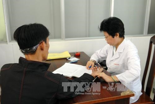 Bác sỹ kiểm tra sức khỏe của bệnh nhân khi đến điều trị tại cơ sở. Ảnh: Mạnh Linh-TTXVN Bác sỹ kiểm tra sức khỏe của bệnh nhân khi đến điều trị tại cơ sở. Ảnh: Mạnh Linh-TTXVN