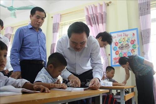 Bộ trưởng Bộ Giáo dục và Đào tạo Phùng Xuân Nhạ đến thăm hỏi, động viên, chia sẻ những khó khăn với giáo viên và học sinh vùng lũ huyện Quan Sơn (Thanh Hóa). Ảnh: TTXVN