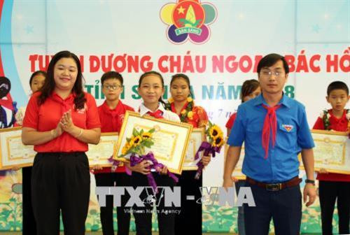 Đại diện Tỉnh đoàn Sơn La trao Bằng khen thi đua làm theo 5 điều Bác Hồ dạy cho em Đinh Thảo Ly (huyện Sốp Cộp). Ảnh: Diệp Anh - TTXVN