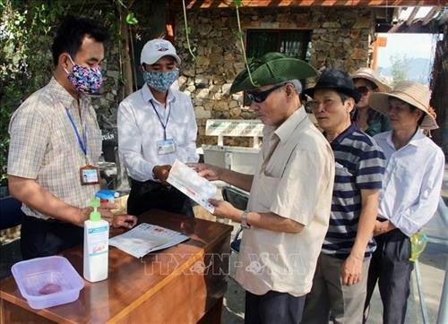 Du khách được cung cấp tờ rơi phòng chống dịch bệnh COVID-19. Ảnh: Xuân Triệu - TTXVN