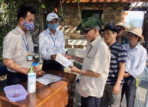 Du khách được cung cấp tờ rơi phòng chống dịch bệnh COVID-19. Ảnh: Xuân Triệu - TTXVN