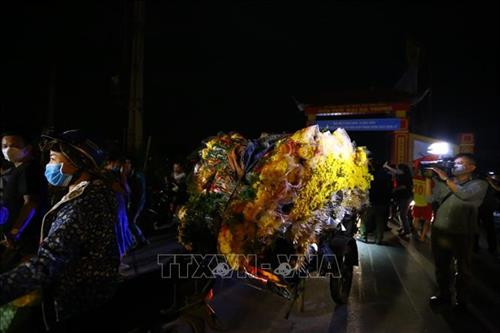 Người dân mang hoa ra chợ bán trong ngày đầu dỡ bỏ cách ly. Ảnh: Minh Quyết - TTXVN